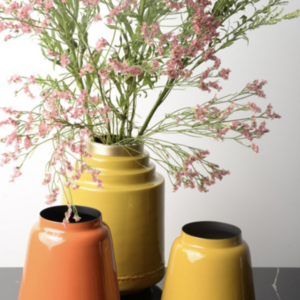 Le vase Olia en fer émaillé jaune est présenté dans un cadre lumineux, mettant en valeur sa couleur éclatante.